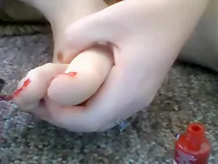painting toes red while naked