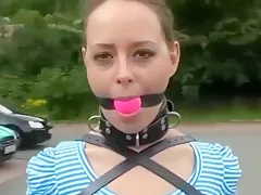 teen 18+ walking in the street with a armbinder, ballgag...